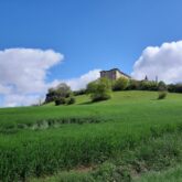 Paysage de la campagne gersoise avec un monument sur les hauteurs
