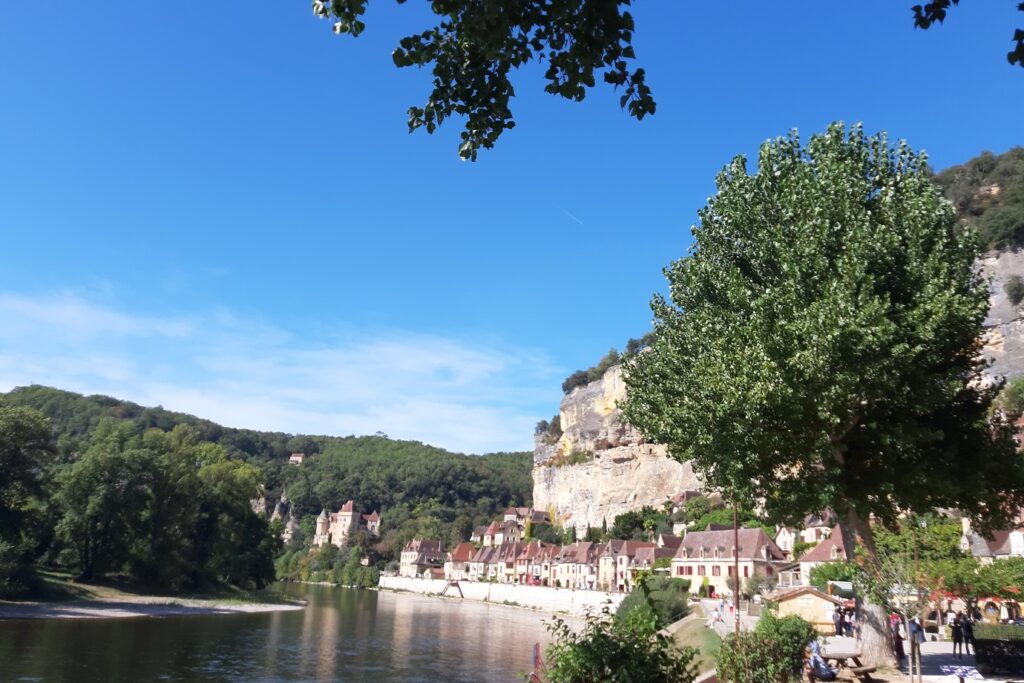 Paysage d'un village de Dordogne avec à ses pieds une étendue d'eau