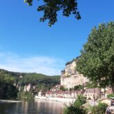 Paysage d'un village de Dordogne avec à ses pieds une étendue d'eau