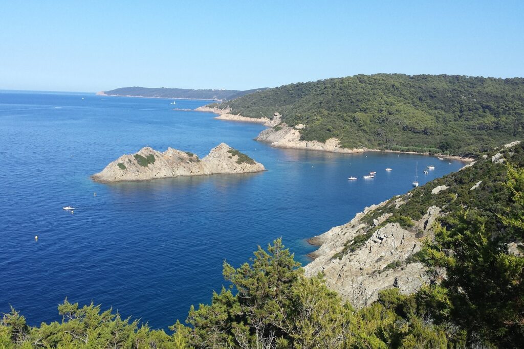 Vue de haut de la baie d'une île, avec la mer et les différentes couleurs de cette dernière
