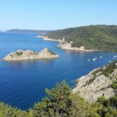 Vue de haut de la baie d'une île, avec la mer et les différentes couleurs de cette dernière