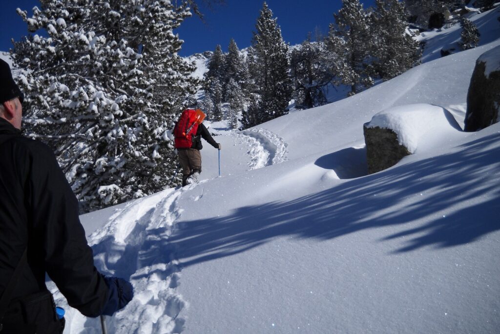 Groupe de randonneurs sur un sentier de randonnée en montée à travers la neige en raquettes