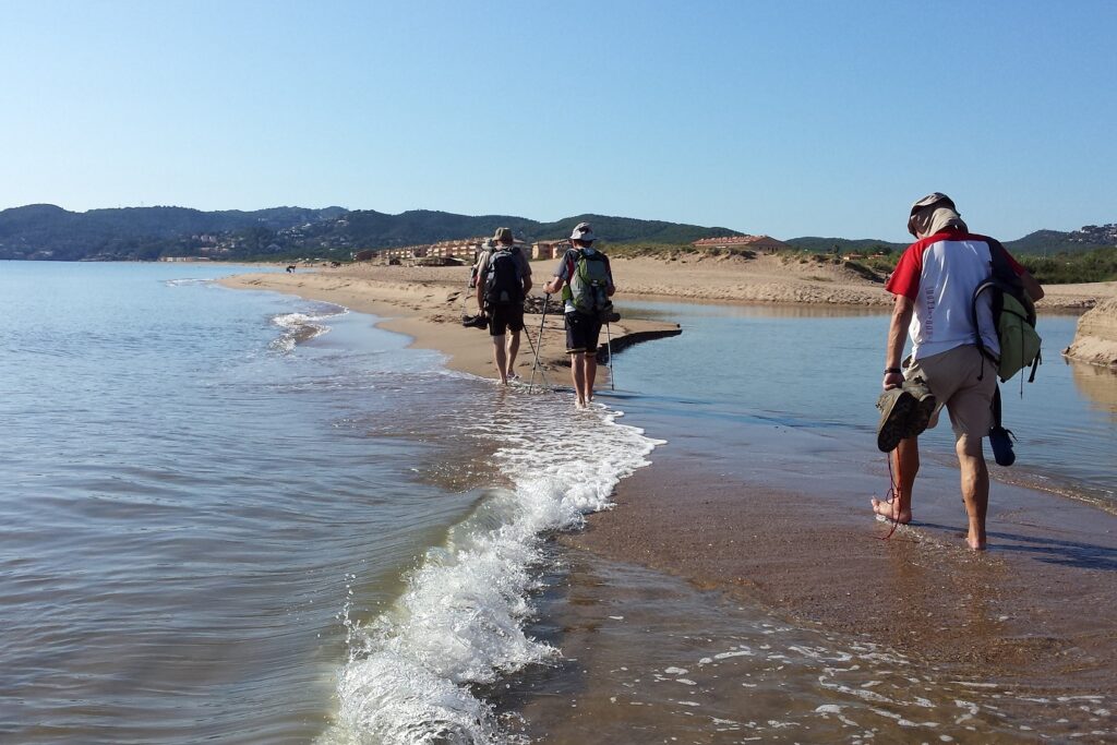 groupe de navigateurs en train de traverser en marchant un bras de mer sur la Costa Brava