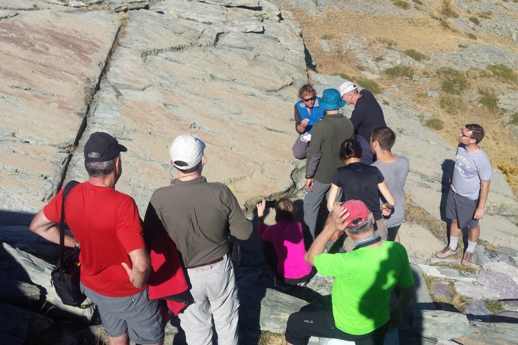 Groupe de randonneurs sur un sentier avec leur guide en train d'observer des roches