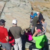 Groupe de randonneurs sur un sentier avec leur guide en train d'observer des roches