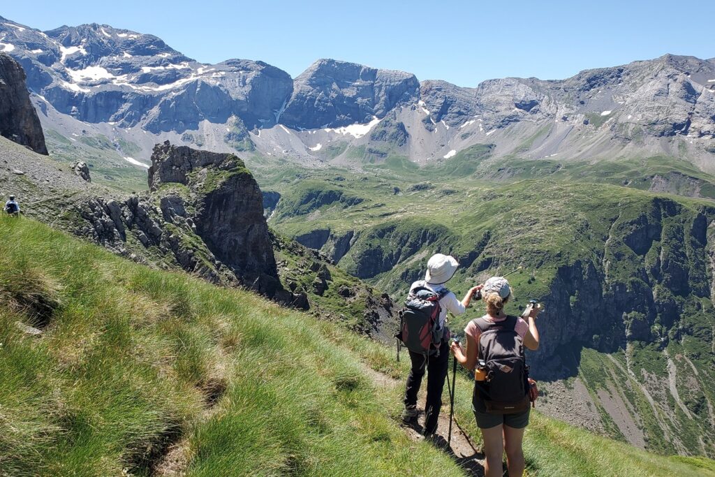 Groupe de randonneurs sur un sentier avec en fond des sommets