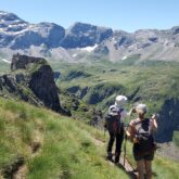 Groupe de randonneurs sur un sentier avec en fond des sommets