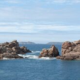 Paysage pris de vue en recul qui donne sur des roches au sein de l'océan