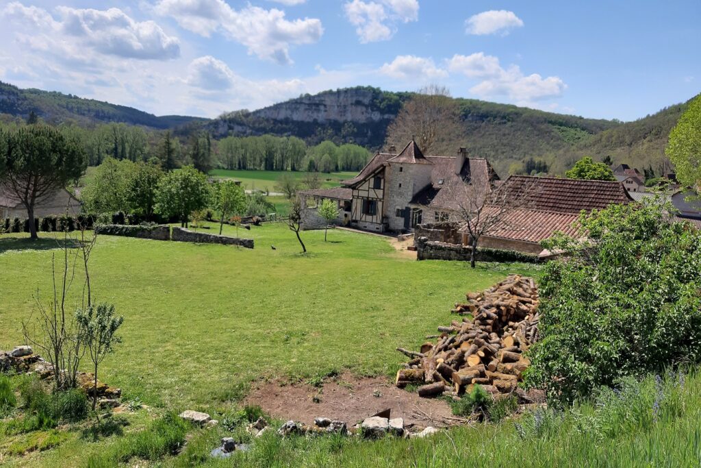 Paysage de la campagne du lot avec un bâtiment historique à l'arrière-plan