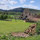 Paysage de la campagne du lot avec un bâtiment historique à l'arrière-plan