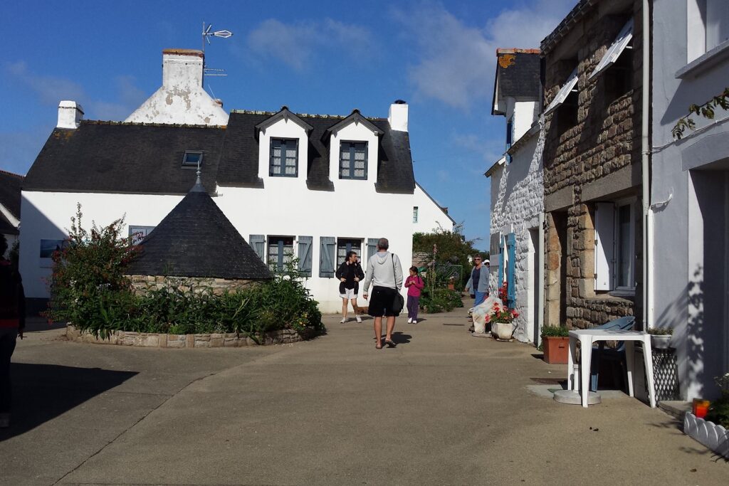 Paysage d'un village de Bretagne en bord d'océan avec un village typique avec des maisons blanches aux toits noirs