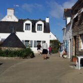 Paysage d'un village de Bretagne en bord d'océan avec un village typique avec des maisons blanches aux toits noirs