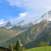 Paysage de montagne avec différents sommets sur la droite et un paysage de vallées de différentes couleurs sur la gauche