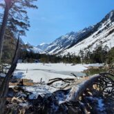 Paysage enneigé aux abords d'un la de montagne dans le massif du Néouvielle encadré de sommets et de paysages hivernaux