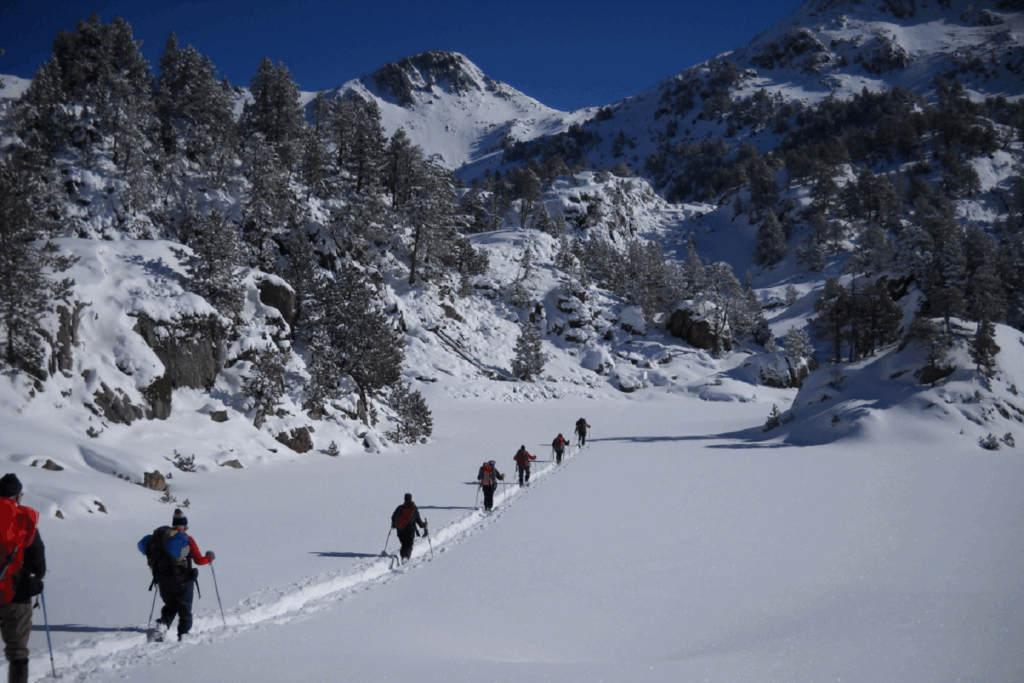 Paysage dans les encantats d'un groupe de randonneurs sur un sentier tracé à travers la neige