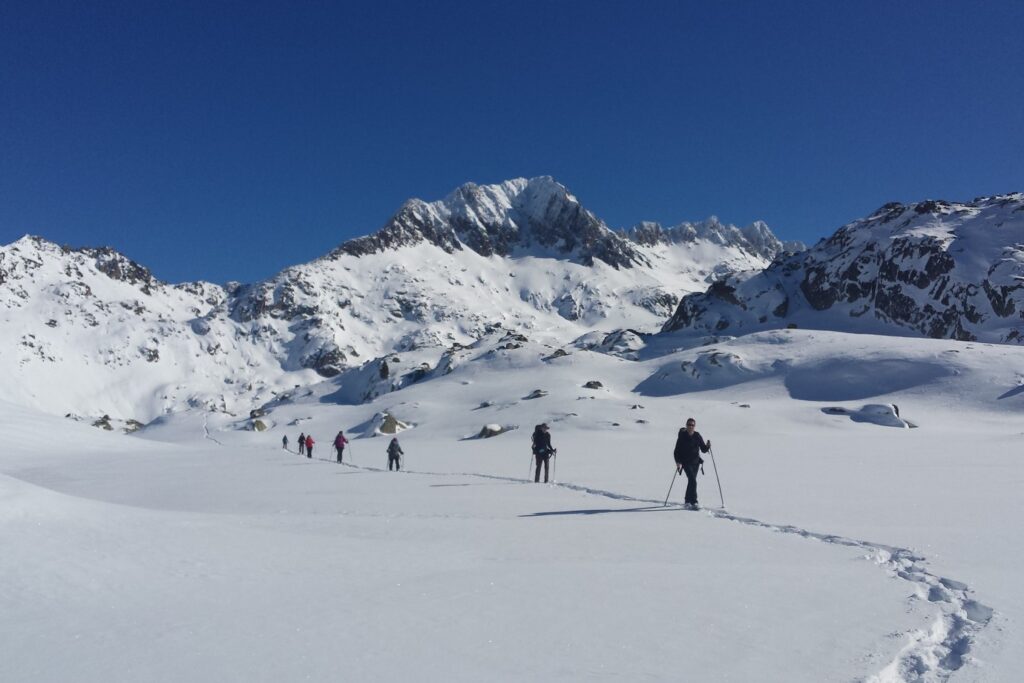Paysage hivernal dans les encantats, avec un groupe de randonneurs sur un sentier avec leur guide lors d'une randonnée en raquettes