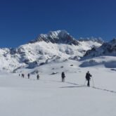 Paysage hivernal dans les encantats, avec un groupe de randonneurs sur un sentier avec leur guide lors d'une randonnée en raquettes