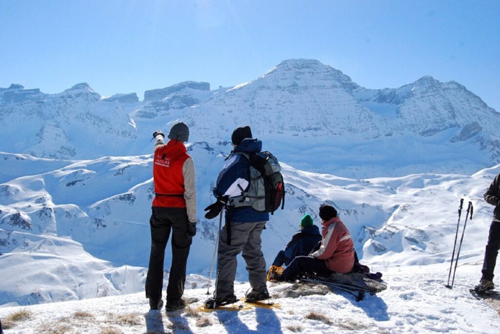 Groupe de randonneurs avec leur guide en train d'observer la vue des différents sommets