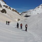 Groupe de randonneurs en raquettes avec leur guide sur un sentier dans un vallon d'une montagne entre Gavarnie et Cauterets