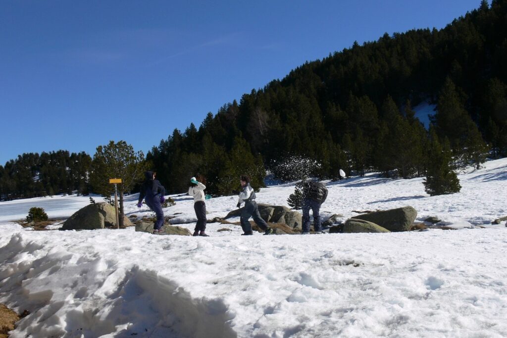 Groupe de randonneurs en famille au cours d'une bataille de boules de neige en Cerdagne