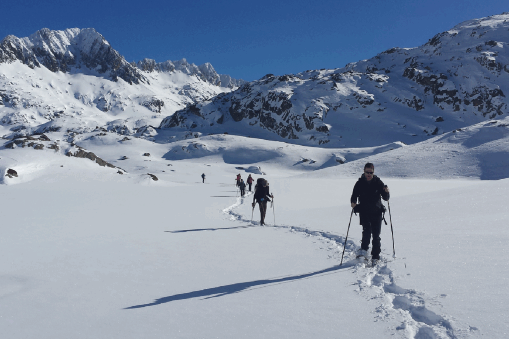 Groupe de randonneurs dans les encantats avec leur guide, dans la neige au cours d'une randonnée en raquettes