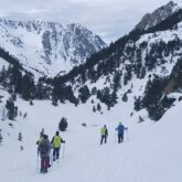 Groupe de randonneurs avec leur guide sur un sentier de randonnée entre Cauterets et le Néouvielle, le paysage est enneigé avec en fond des sommets