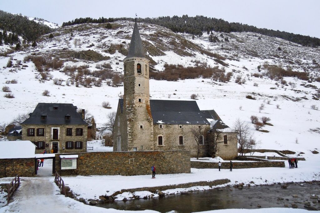 Vue, en hiver, sur le sanctuaire de Montgarri avec le cours d'eau qui traverse ce village espagnol