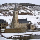 Vue, en hiver, sur le sanctuaire de Montgarri avec le cours d'eau qui traverse ce village espagnol