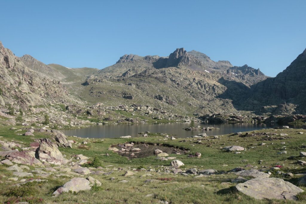 Paysage montagnard dans le Mercantour avec des sommets en fond et un lac au premier plan
