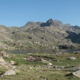 Paysage montagnard dans le Mercantour avec des sommets en fond et un lac au premier plan