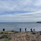 Groupe de randonneurs sur un sentier de randonnée avec la mer en arrière plan