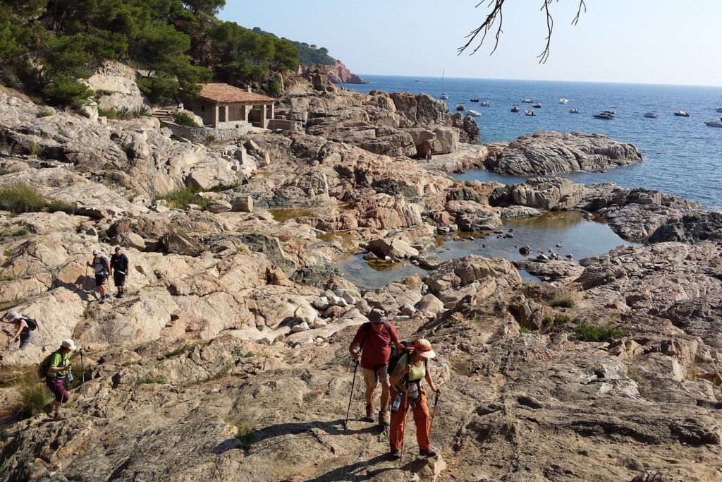 Groupe de randonneurs qui marchent dans les rochers en Costa Brava