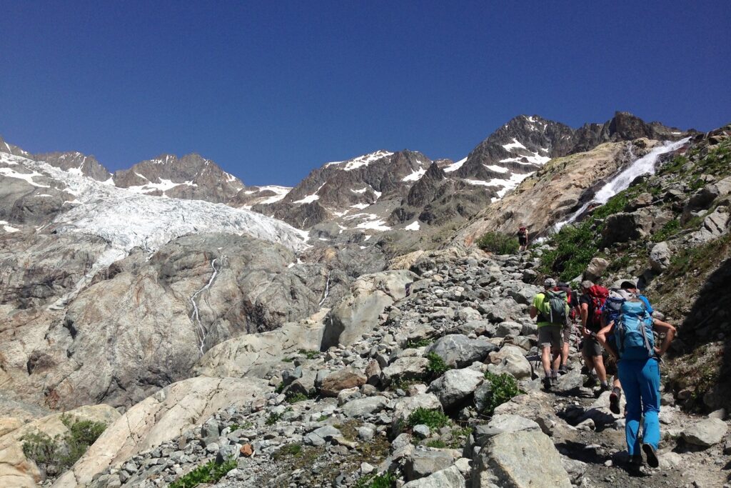 Groupes de randonneurs sur un sentier de randonnée avec leur guide dans le parc national des écrins, dans les alpes