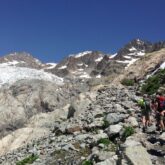 Groupes de randonneurs sur un sentier de randonnée avec leur guide dans le parc national des écrins, dans les alpes