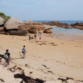 Groupe de randonneurs sur un sentier sur le sable sur la côte de granit rose en Bretagne