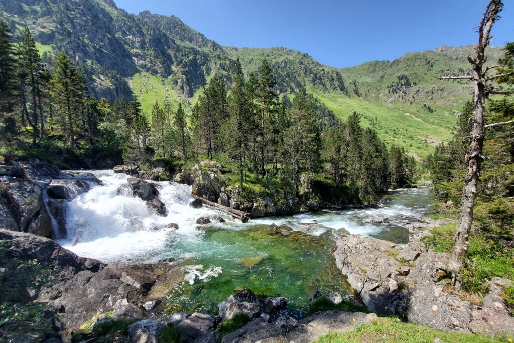 Paysage de montagne avec une cascade, à l'arrière-plan des sommets et une forêt