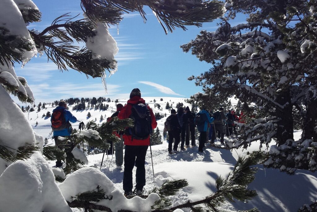 Groupe de randonneurs sur un sentier de randonnée en raquettes avec leur guide, lors d'un séjour de randonnée en raquettes au pied du pic du midi de Bigorre