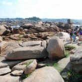 Groupe de randonneurs sur l'île de Bréhat en Bretagne avec leur guide sur un sentier de rochers