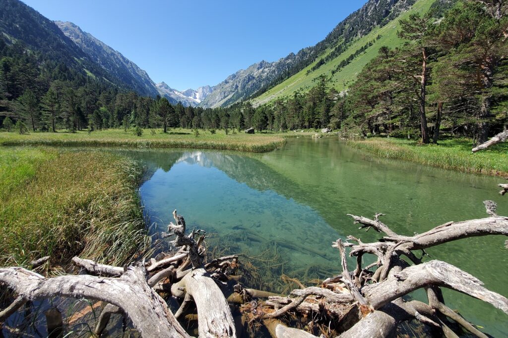 Paysage avec un lac de montagne au premier plan, avec des montagnes de chaque côté