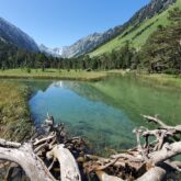 Paysage avec un lac de montagne au premier plan, avec des montagnes de chaque côté