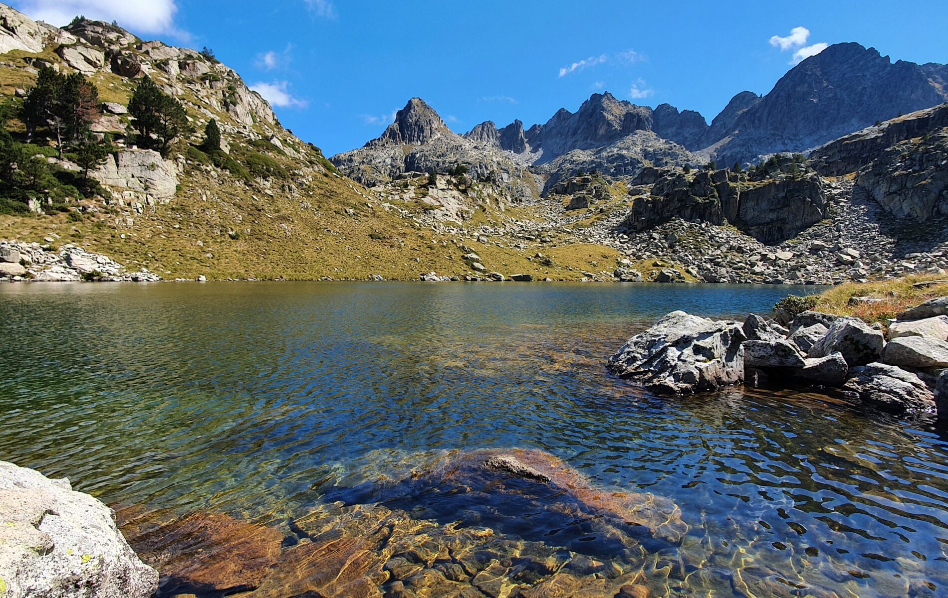 Randonneurs autour d'un lac de montagne lors d'un séjour de randonnée accompagnés d'un guide de montagne