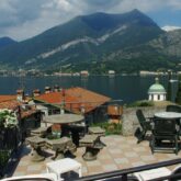 Paysage au bord du lac de Côme en Italie avec les montagnes en fond et des maisons au premier plan