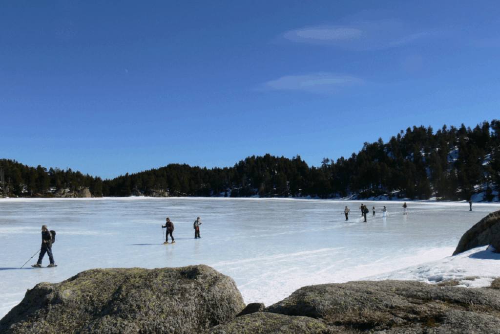 Groupe de familles en train de faire du patin à glace lors d'un séjour multi-activités en hiver en Cerdagne