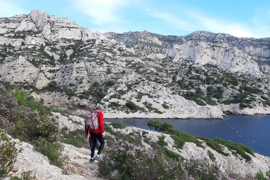 Groupe de randonneurs sur un sentier au-dessus d'une falaise dans les calanques de Cassis avec la mer en contrebas