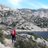 Groupe de randonneurs sur un sentier au-dessus d'une falaise dans les calanques de Cassis avec la mer en contrebas