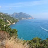 Paysage de bord de mer avec la mer sur la droite et sur la gauche des sommets