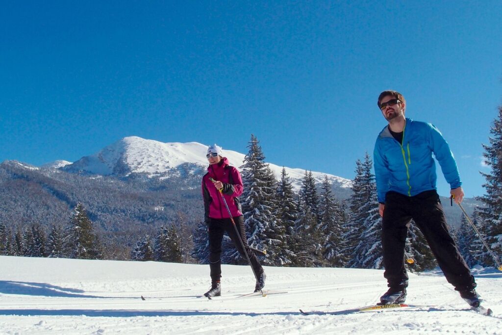 Deux personnes en ski de fond dans le Vercors avec un guide lors d'un séjour de découverte du skating