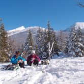 groupe de randonneurs qui prennent leur pique-nique dans la neige lors d'un séjour accompagné d'un guide de balades en ski de fond dans le Vercors