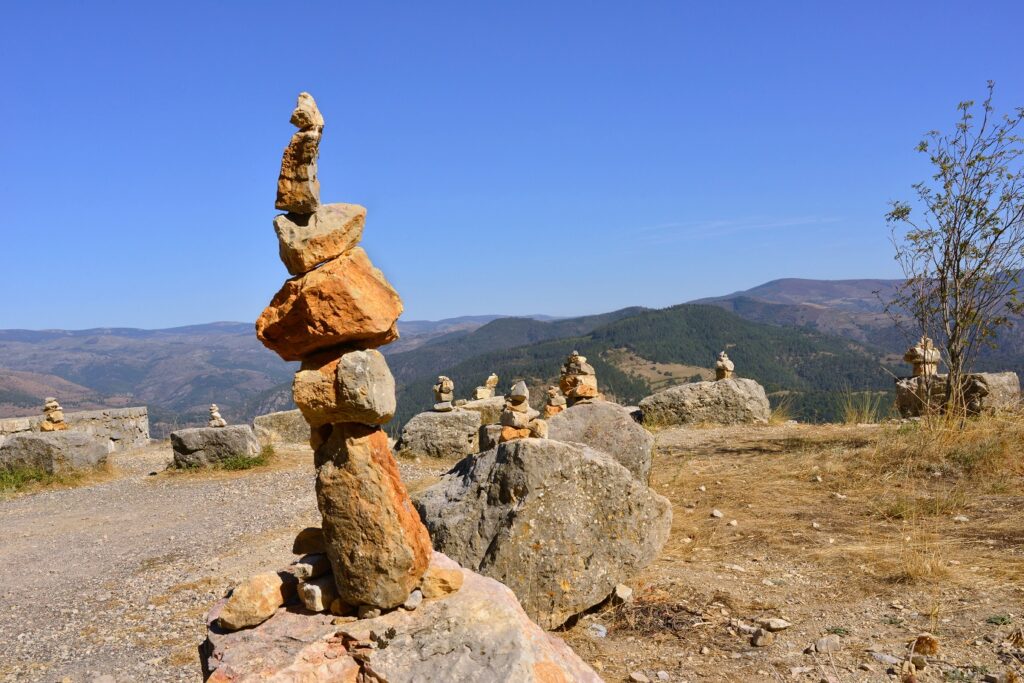 Paysage en haut d'un sommet avec des marqueurs de randonnées, aussi appelés cairns, qui sont un empilement de pierre pour marquer un chemin