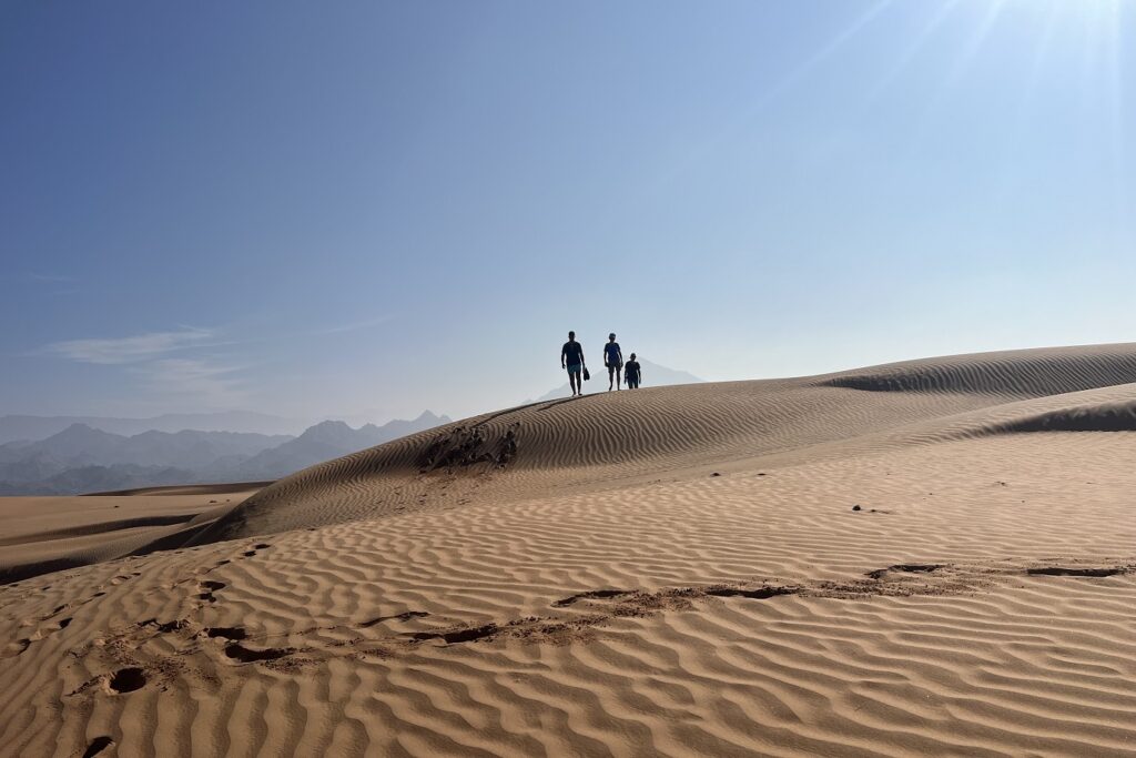 Groupe de randonneurs marchant sur des dunes de sable dans le désert d'Oman